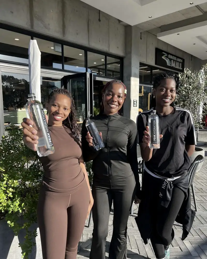 Three women holding up Peak Hydration after a session
