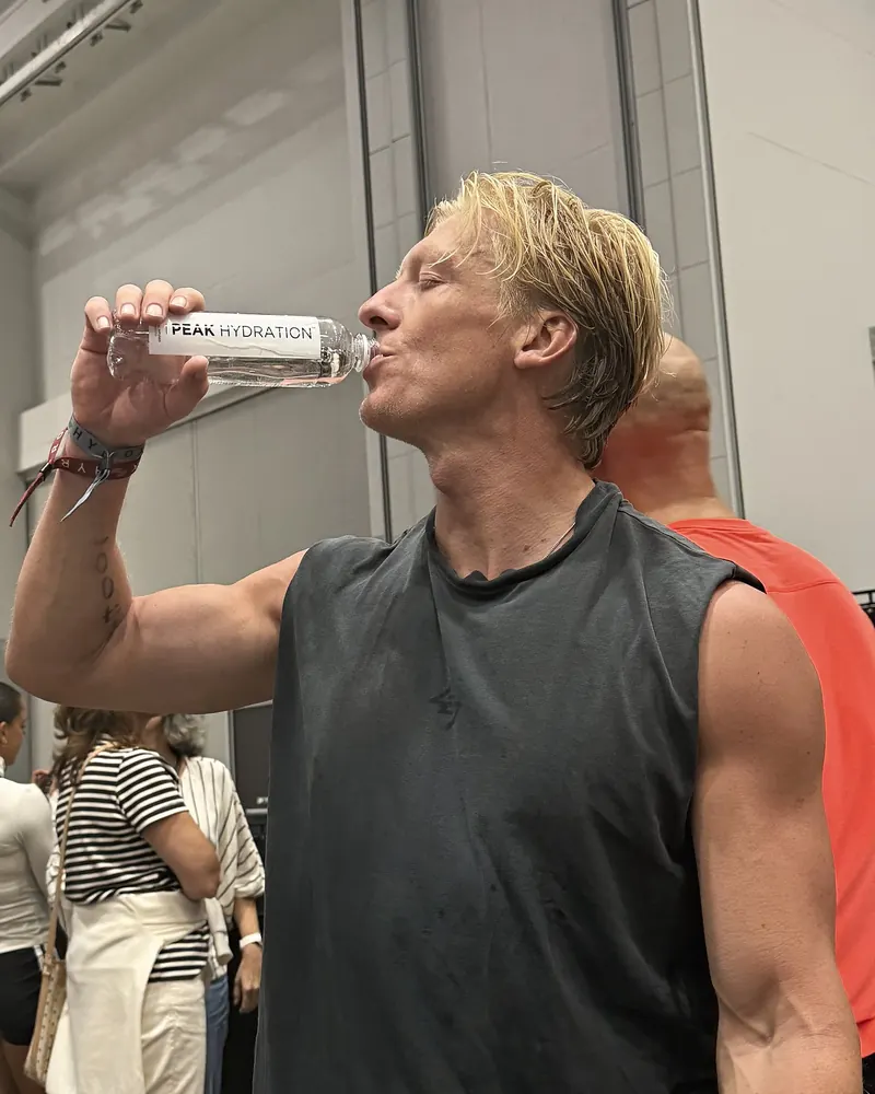 A man drinking Peak Hydration sparkling at an event